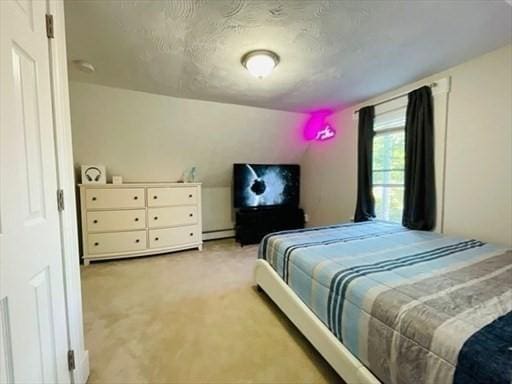 bedroom featuring a baseboard heating unit and light colored carpet
