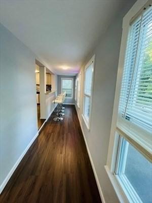 corridor featuring baseboards and dark wood finished floors
