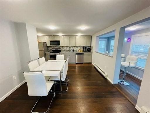 dining area featuring dark wood-type flooring, baseboards, and baseboard heating