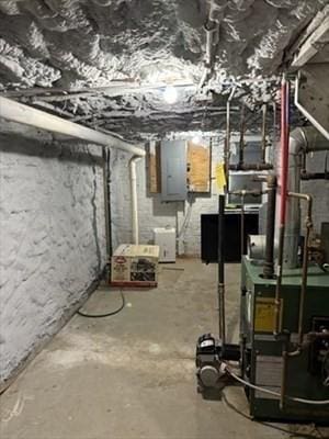 unfinished below grade area with a heating unit and electric panel