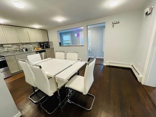 dining space with a baseboard radiator and dark wood-style flooring