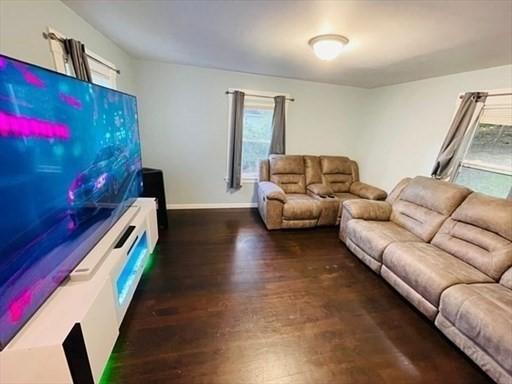 living area with baseboards and wood finished floors