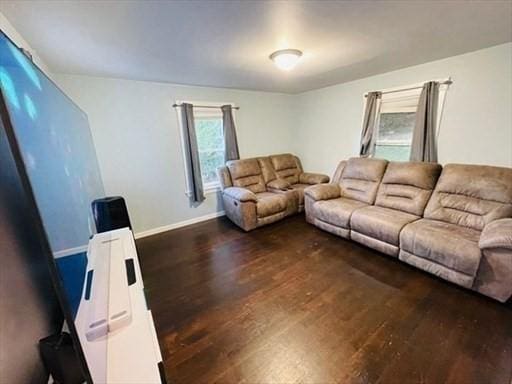 living area with baseboards and dark wood finished floors