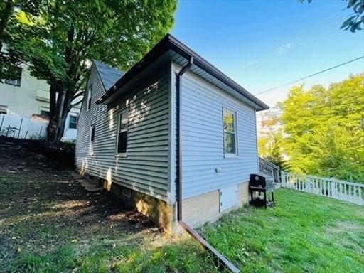 view of side of property with fence and a lawn