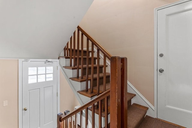 staircase featuring lofted ceiling