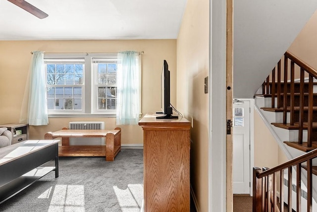 living area featuring carpet flooring, radiator, and ceiling fan