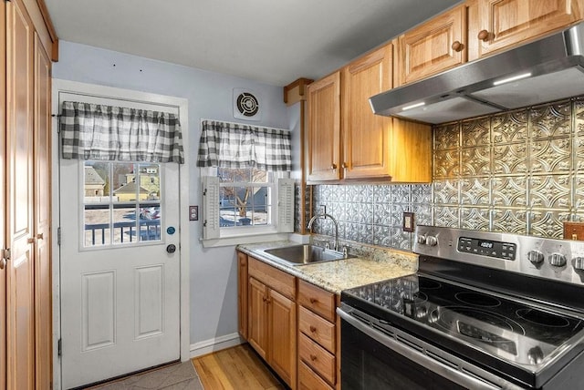 kitchen with light stone counters, sink, decorative backsplash, and electric range