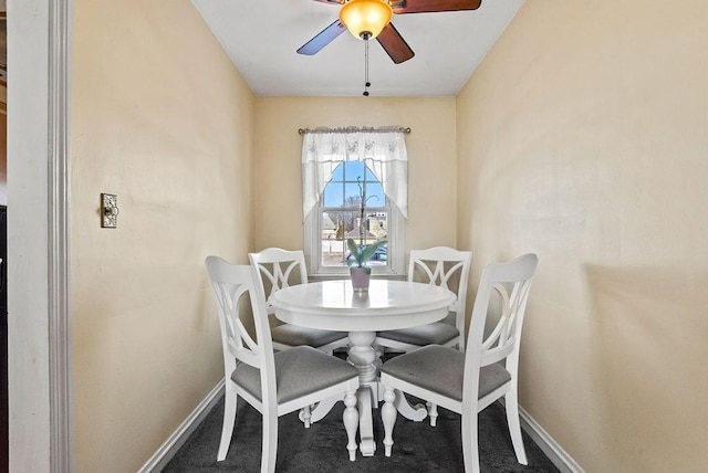 carpeted dining room with ceiling fan