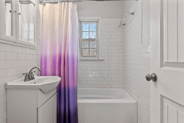 bathroom featuring vanity, shower / bath combo with shower curtain, and tile walls