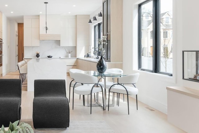 kitchen with tasteful backsplash, light countertops, recessed lighting, white cabinets, and modern cabinets