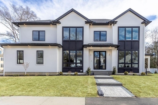 modern farmhouse featuring stucco siding and a front yard