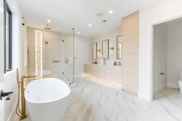 full bathroom with a shower stall, recessed lighting, a freestanding tub, marble finish floor, and vanity