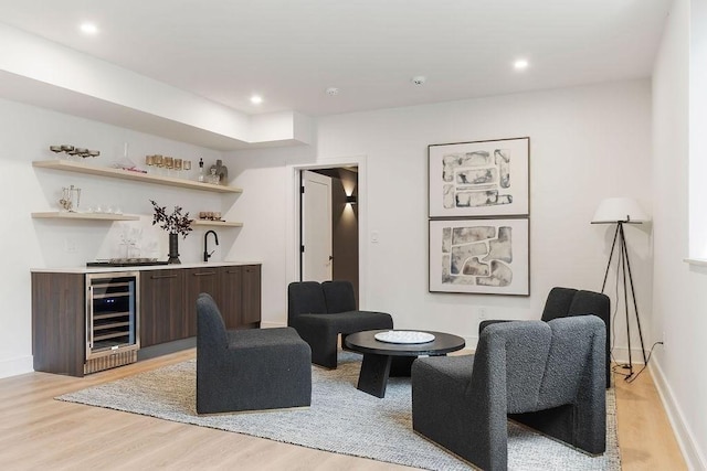 living area with wine cooler, recessed lighting, wet bar, and light wood-style floors