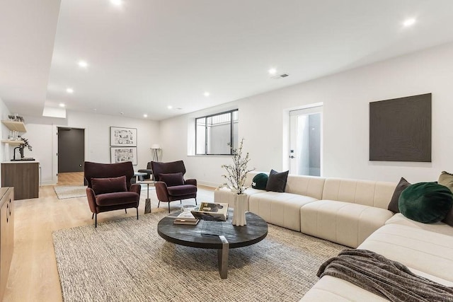 living room with recessed lighting, visible vents, and light wood-type flooring