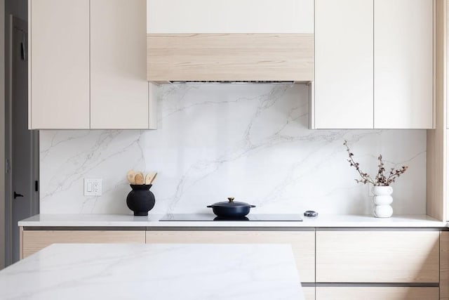 kitchen featuring black electric stovetop, tasteful backsplash, modern cabinets, and white cabinets