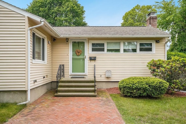 177 Elm St, Andover, MA 01810 - view of exterior entry with a chimney and roof with shingles