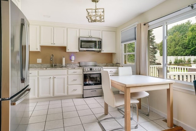 177 Elm St, Andover, MA 01810 - kitchen featuring appliances with stainless steel finishes, light tile patterned floors, white cabinets, and decorative light fixtures