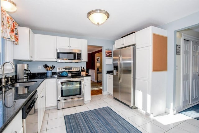 kitchen featuring white cabinetry, appliances with stainless steel finishes, light tile patterned flooring, and sink