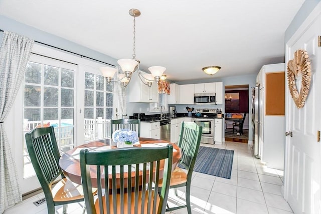 dining area with a chandelier, sink, and light tile patterned floors