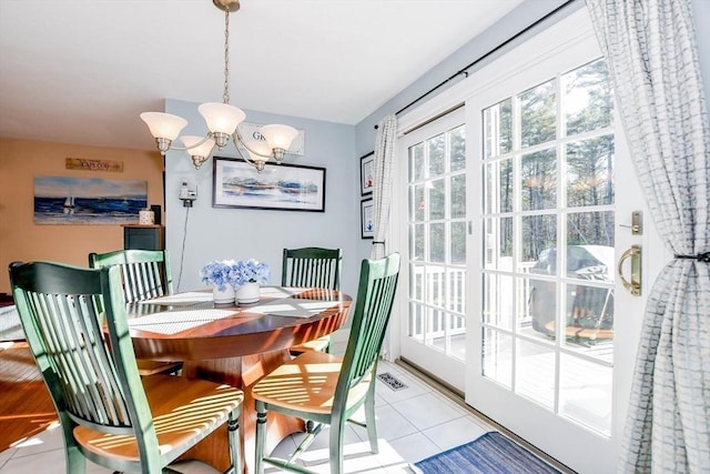 dining area with light tile patterned flooring and a chandelier