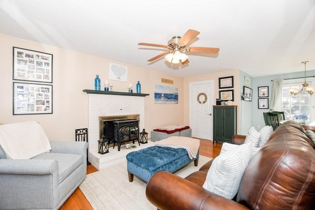 living room featuring ceiling fan with notable chandelier and light hardwood / wood-style floors