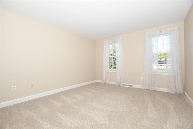 spare room with plenty of natural light and carpet flooring