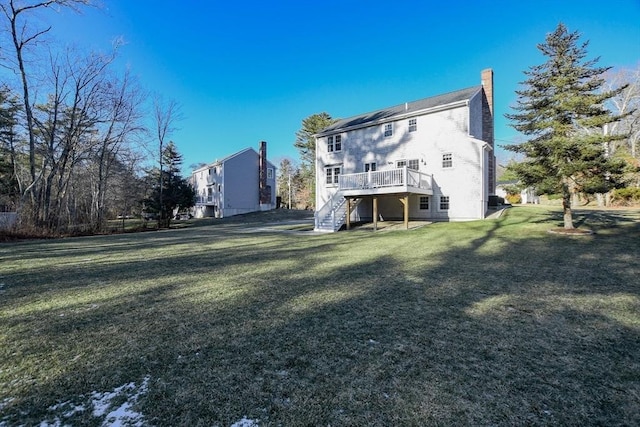 rear view of property featuring a wooden deck and a yard