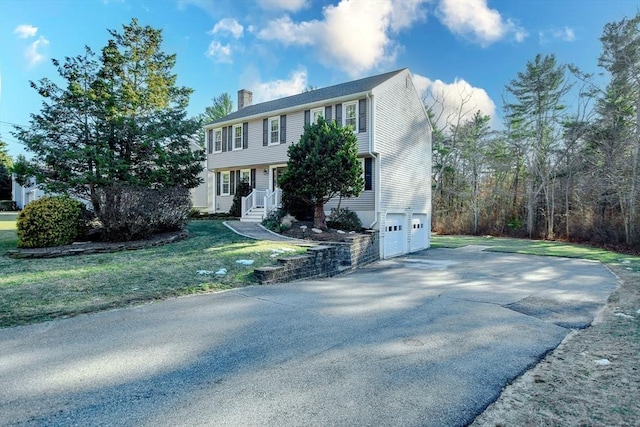 colonial house featuring a garage and a front yard