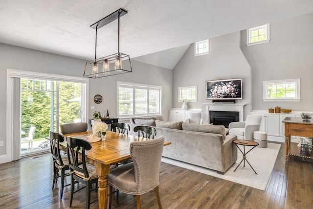 41 Old Main Rd Unit 3A, Falmouth, MA 02556 - dining space with dark wood-type flooring, a fireplace, and high vaulted ceiling