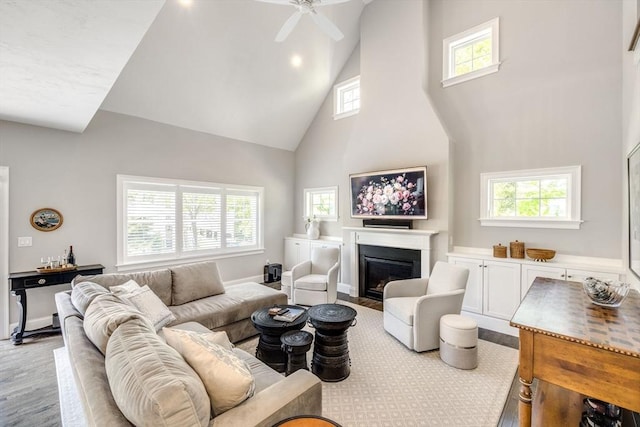 41 Old Main Rd Unit 3A, Falmouth, MA 02556 - living room featuring high vaulted ceiling, ceiling fan, a glass covered fireplace, wood finished floors, and baseboards