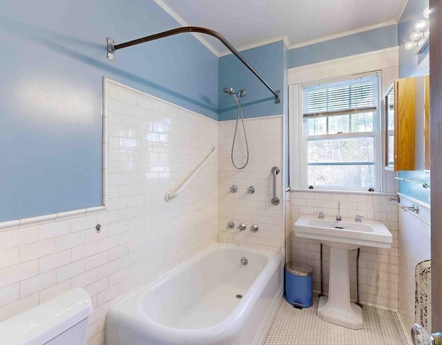 bathroom featuring toilet, tiled shower / bath combo, tile patterned flooring, and tile walls