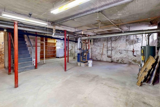 basement with water heater and washer / dryer