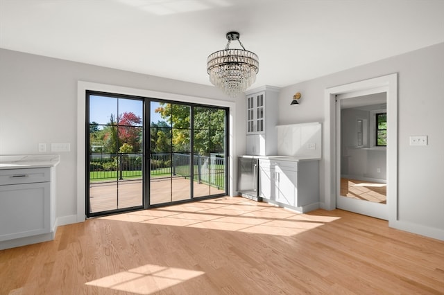 interior space with a notable chandelier and light hardwood / wood-style flooring