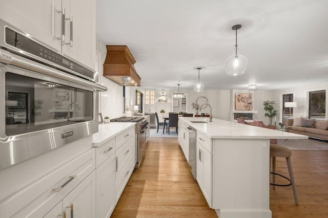 13 Alden Rd, Andover, MA 01810 - kitchen featuring appliances with stainless steel finishes, a sink, a breakfast bar, and light wood-type flooring