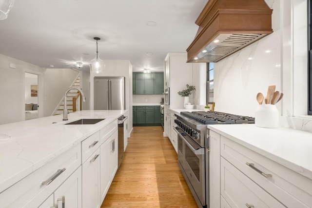 13 Alden Rd, Andover, MA 01810 - kitchen featuring premium appliances, a sink, premium range hood, light wood-type flooring, and hanging light fixtures