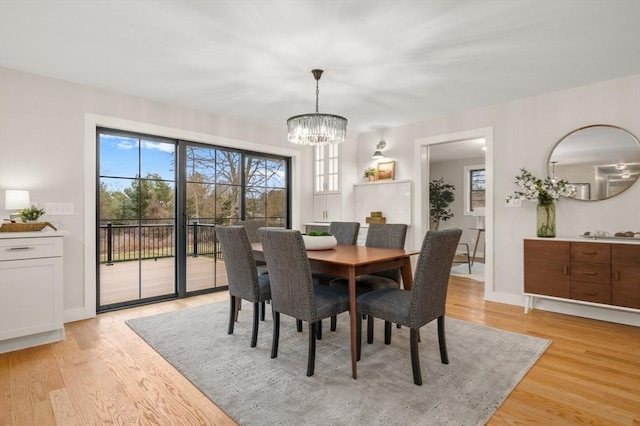 13 Alden Rd, Andover, MA 01810 - dining area featuring light wood finished floors, plenty of natural light, baseboards, and an inviting chandelier