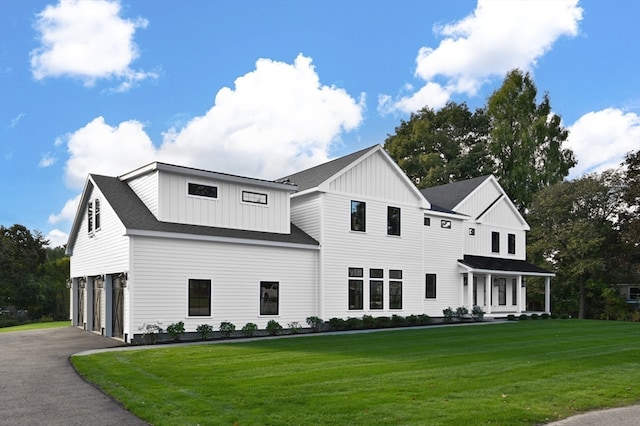 view of front of home featuring a garage, a front lawn, and covered porch