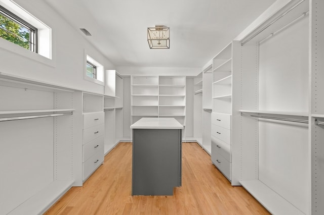 walk in closet with light hardwood / wood-style floors