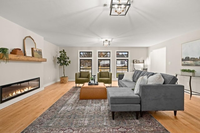 13 Alden Rd, Andover, MA 01810 - living room with baseboards, a notable chandelier, a glass covered fireplace, and wood finished floors