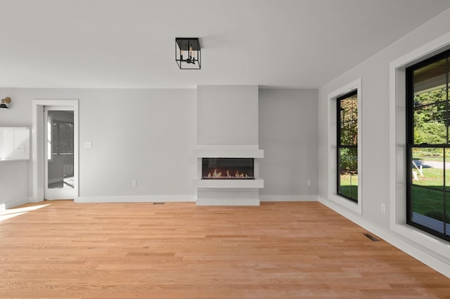 unfurnished living room with light hardwood / wood-style floors and a large fireplace