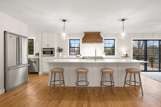 13 Alden Rd, Andover, MA 01810 - kitchen with light countertops, custom exhaust hood, white cabinetry, and appliances with stainless steel finishes