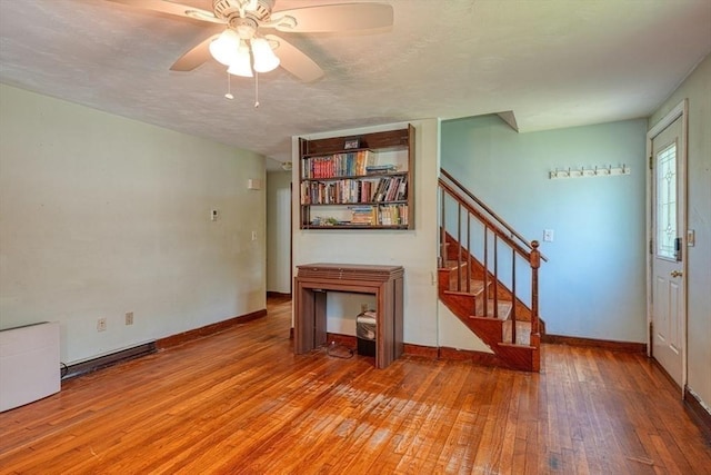 10 Laurel Ln, Bellingham, MA 02019 - unfurnished living room featuring light wood-type flooring, stairway, a ceiling fan, and a textured ceiling