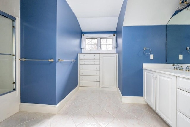 full bathroom with vanity, baseboards, enclosed tub / shower combo, lofted ceiling, and tile patterned floors