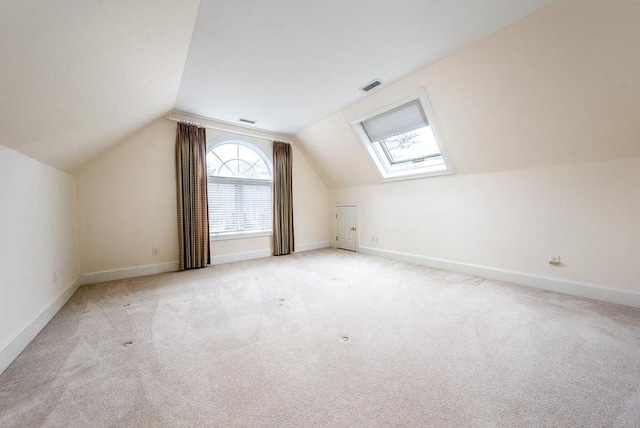 bonus room featuring lofted ceiling with skylight, baseboards, and visible vents