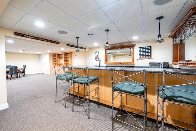 bar featuring visible vents, pendant lighting, a sink, carpet floors, and indoor wet bar