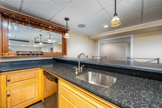 kitchen featuring a sink, a drop ceiling, dishwasher, and hanging light fixtures