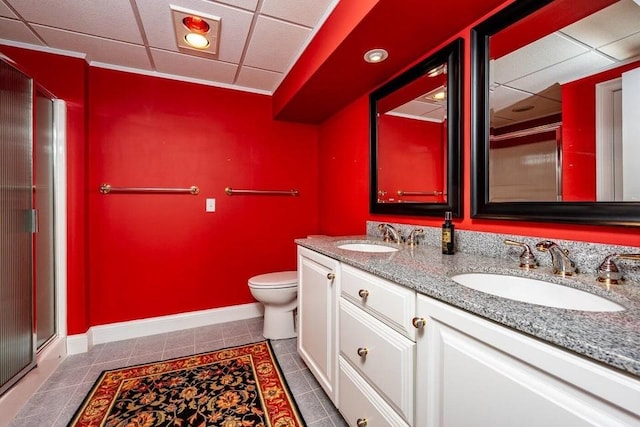 full bath with tile patterned flooring, double vanity, toilet, and a sink