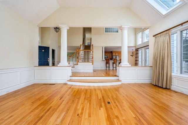 interior space with decorative columns, visible vents, wood finished floors, and stairs