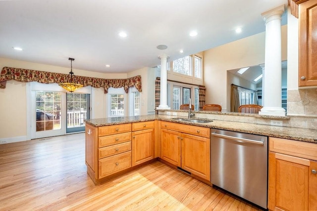 kitchen featuring dishwasher, light stone countertops, ornate columns, and a sink