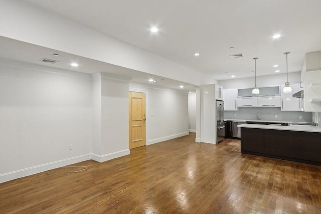 kitchen featuring white cabinetry, dark hardwood / wood-style flooring, backsplash, stainless steel fridge, and pendant lighting